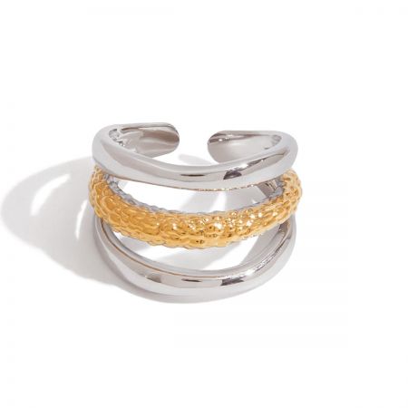 Gedetailleerd uitzicht op een bicolor ring uit de set, met de nadruk op de gestructureerde gouden middenband en de gladde zilveren buitenbanden.