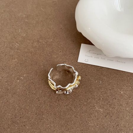 Vista detallada del anillo de lazo de latón chapado en oro y plata, destacando su diseño único.