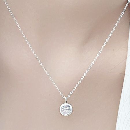 Collier en charme de pièce de monnaie porte-bonheur en argent sterling 925 en gros - Un gros plan en studio d'un collier en argent sterling 925 avec un pendentif en forme de pièce 'Bonne Chance', sur un fond blanc propre.