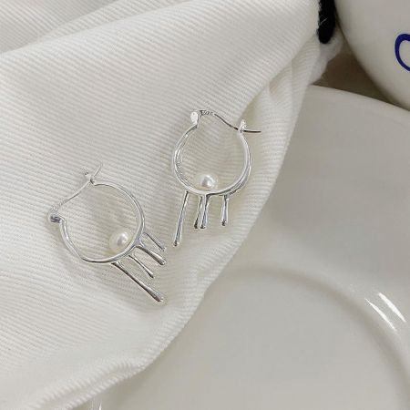 Vista dettagliata degli orecchini a cerchio liquido in argento sterling 925 che mostrano la perla e la chiusura a scatto.