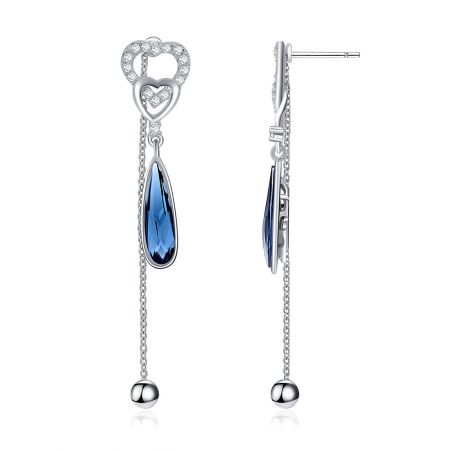 Zijaanzicht van de blauwe Swarovski hart dangle oorbellen die het zilveren vakmanschap en de kristal schittering tonen.