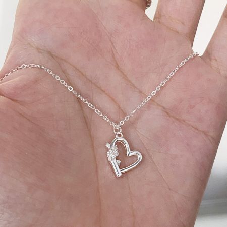 Vue détaillée d'un collier pendentif en argent 925 en forme de cœur et de clé avec des pierres CZ.
