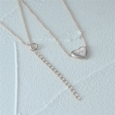 La collana a cuore d'argento mostrata con la sua catena di estensione e chiusura per lunghezza regolabile.