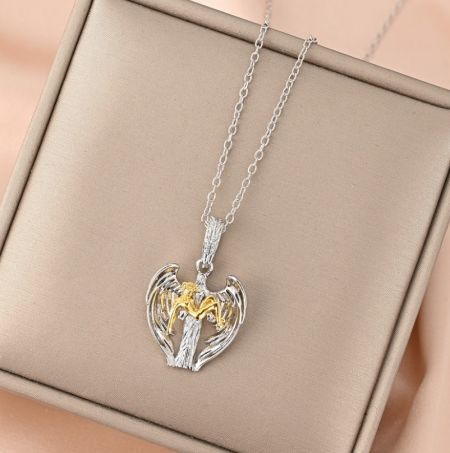 Collana personalizzata con ali d'angelo - Collana personalizzata con ali d'angelo e un pendente a forma di cuore in argento con ali dorate, presentata in una scatola per gioielli. Prodotto da JR Fashion Accessories.