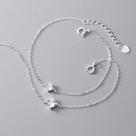 Due bracciali in argento sterling con un singolo zirconio mostrati affiancati per confrontare le diverse dimensioni delle pietre.