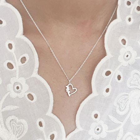 Collier pendentif en cœur ajouré en argent sterling 925 en gros. - Un modèle portant un collier pendentif en argent sterling 925 en forme de cœur ajouré avec un design de flèche, faisant partie d'un ensemble de gros.