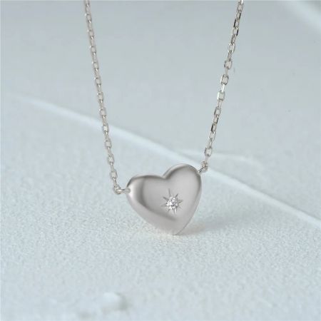 Primo piano del pendente a cuore d'argento, evidenziando l'accento in zirconia.