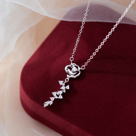 Close-up of a sterling silver heart pendant necklace with a trail of sparkling gemstones.