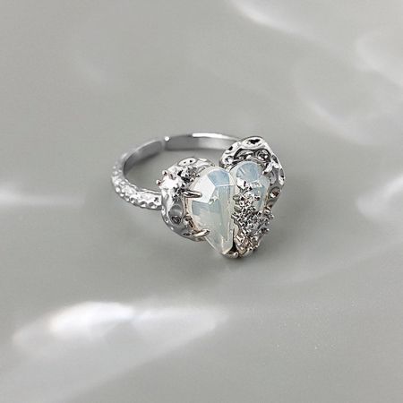 Un anillo ornamentado chapado en plata con un cristal en forma de corazón.