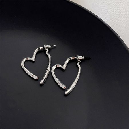 Toma limpia del producto de los pendientes en forma de corazón plateados, destacando su acabado pulido.