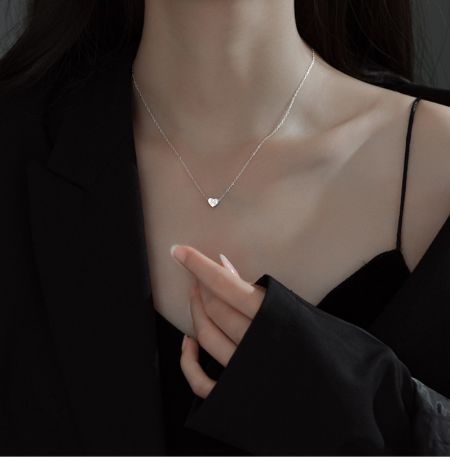 Primer plano del collar de letras en forma de corazón de plata esterlina 925, destacando el brillo del colgante y el detalle de la cadena.