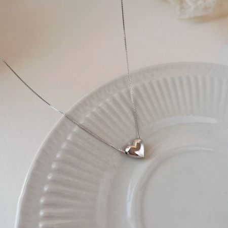 Collar de corazón de plata esterlina 925 - Una toma de estudio en primer plano del collar de corazón de plata esterlina 925, destacando el colgante en forma de corazón pulido.