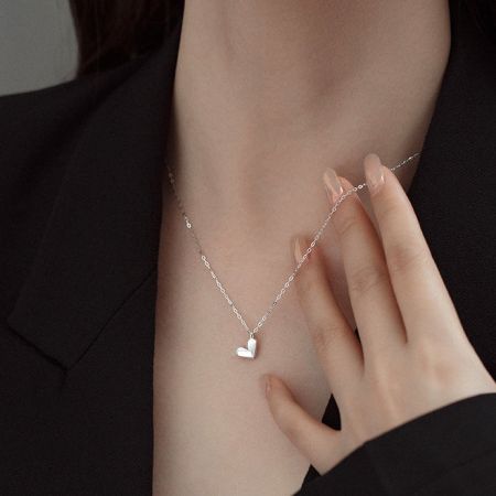 Model wearing the elegant silver heart-shaped pendant necklace.
