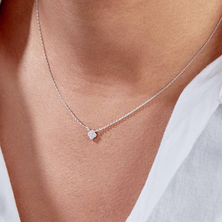 The sterling silver necklace with a clear zircon petal pendant, elegantly worn.