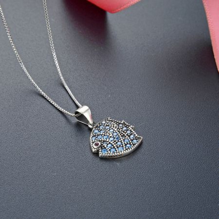 A whimsical 925 sterling silver hedgehog pendant necklace featuring blue and red gemstone details.