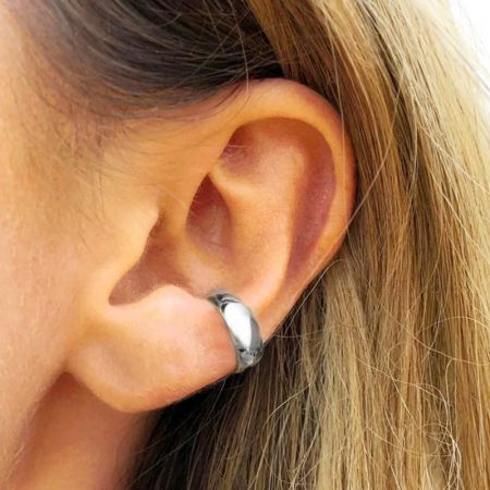 Primo piano del bracciale auricolare a forma di C in argento indossato.