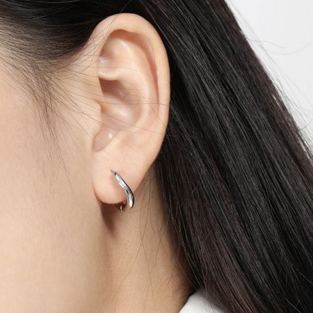 Close-up van een model dat de hypoallergene 925 sterling zilveren versie van de minimalistische creolen draagt.