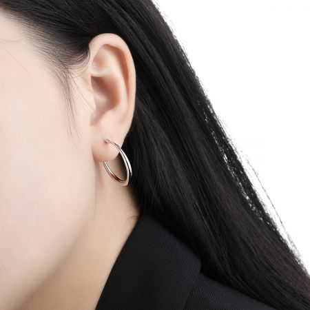 Close-up de um modelo usando o brinco de argola de prata esterlina 925 banhado a ouro branco de 20mm.