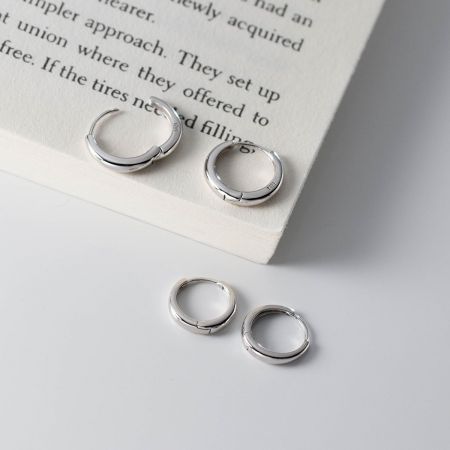 Orecchini a cerchio minimalisti lisci in argento sterling 925 (5 paia) - Un set di cinque orecchini a cerchio minimalisti in argento sterling 925 con una finitura opaca, esposti su uno sfondo pulito e chiaro.