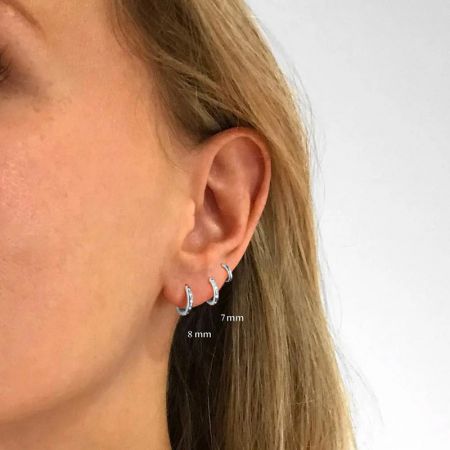 Modello che mostra due orecchini a cerchio in argento sterling per dimostrare diverse dimensioni.