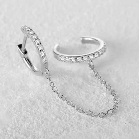 Primo piano della versione in argento sterling degli orecchini a manica a doppio cerchio, che mette in mostra le intricate decorazioni in diamante.