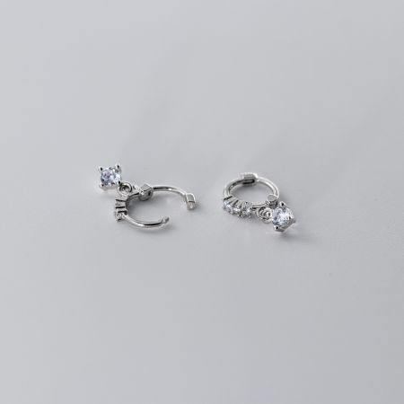 Close-up de brincos de argola minimalistas de prata esterlina com zircônia cúbica brilhante.