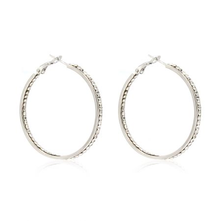 Vue en gros plan détaillée des boucles d'oreilles en rhodium, mettant en valeur le sertissage complexe de la double rangée de cristaux.