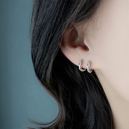 Una donna che indossa gli eleganti orecchini curvi in argento sterling 925 con cristalli in finitura argento.