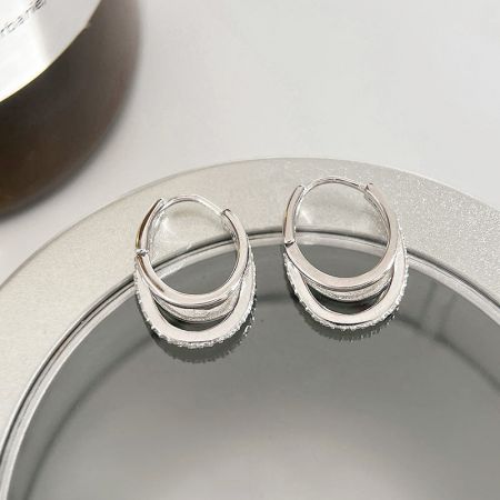 Orecchini a cerchio in argento sterling 925 con pietre CZ a tre strati (set di 5 paia). - Un primo piano dettagliato di orecchini a cerchio in argento sterling 925 con un design unico a tre strati con pietre CZ scintillanti, che mostra un'ottima lavorazione.