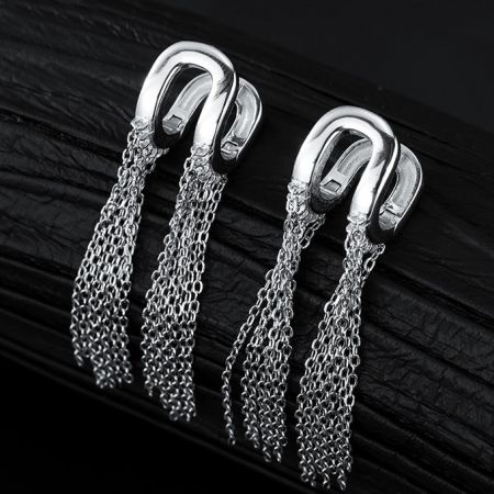 Volledig uitzicht op de sterling zilveren hoefijzer oorbellen met kettingtassels.