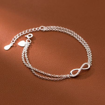 The double chain design of the sterling silver infinity bracelet with decorative charms.