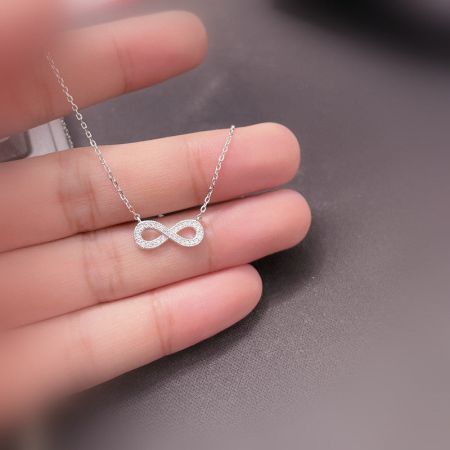 Close-up of the silver infinity pendant necklace, highlighting the brilliant cubic zirconia stones.