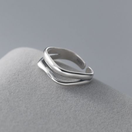 Eine andere Perspektive, die die eleganten, ineinander verschlungenen Konturen des Wellenrings aus Silber zeigt.