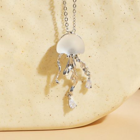 Primo piano del pendente di medusa in argento, enfatizzando la sua finitura lucida e i dettagli delicati.