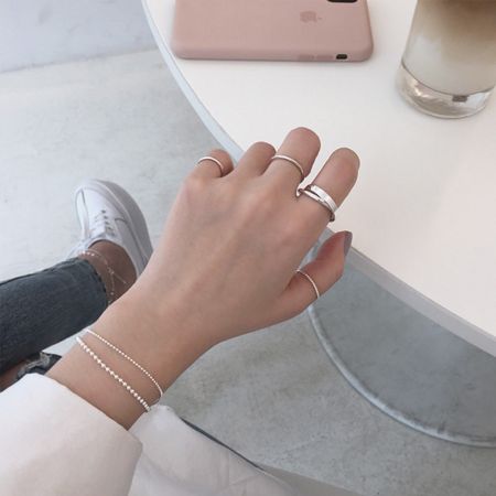A model's hand showcasing the elegant fit of the 925 silver double loop ring, paired with a matching bracelet.