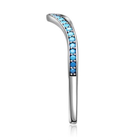 Schuin shot van de zilveren chevronring die de rangschikking van de turquoise cubic zirconia stenen benadrukt.