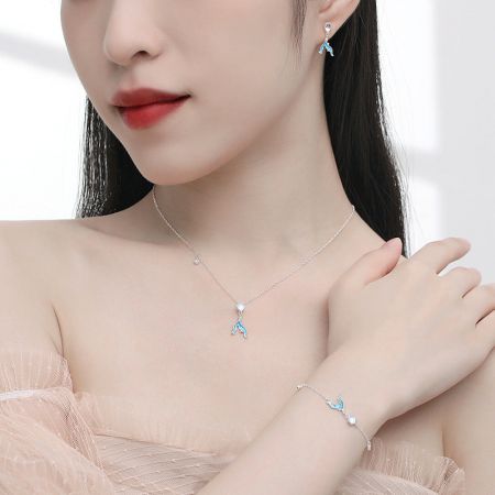 Un ensemble complet de bijoux en argent avec des accents bleus, comprenant des boucles d'oreilles, un collier et un bracelet.
