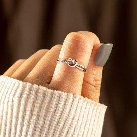 モデルの人差し指に着用されたジルコンアクセント付きのシルバーのノットリング。