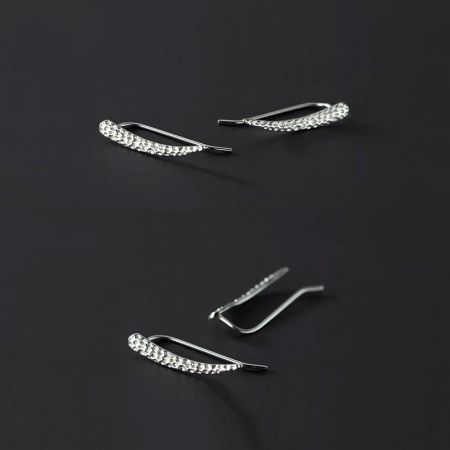 Delicati orecchini climber in argento sterling a forma di foglia con una fila di pietre trasparenti.