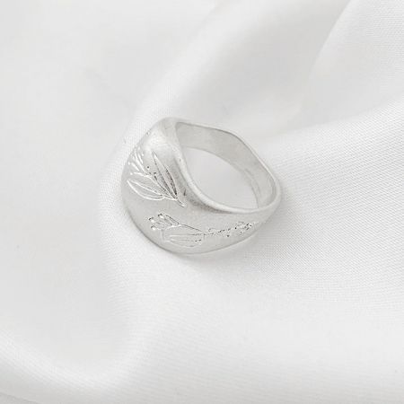 Detailed product shot of the silver brass ring with an elegant leaf engraving.