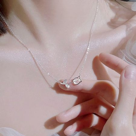광택이 나는 잎 모양의 펜던트를 강조한 미니멀리스트 실버 목걸이.