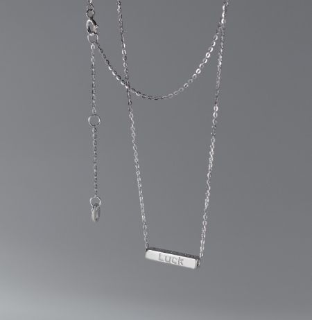 A 925 sterling silver necklace featuring a rectangular pendant engraved with the word 'LUCK'.