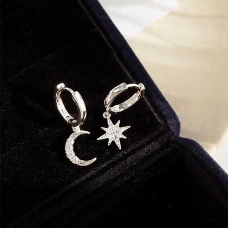 Close-up of the sterling silver version of the star and moon earrings, showcasing the intricate cubic zirconia setting.