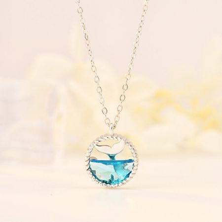 Collar de clavícula con colgante de cola de ballena de lágrimas de sirena de plata esterlina 925 - Un delicado collar de plata esterlina 925 con un elegante colgante de cola de ballena de lágrimas de sirena con una piedra preciosa azul, exhibido sobre un fondo neutro.