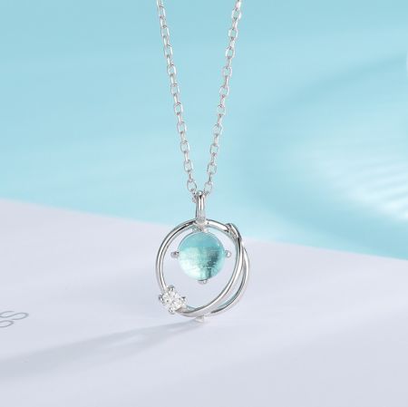 Close-up of a sterling silver necklace with a pale blue-green opal pendant.