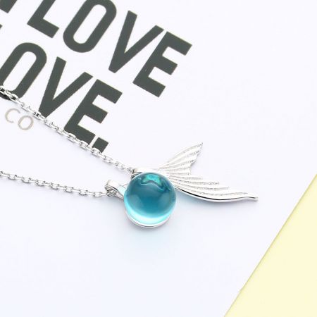 Una collana in argento minimalista che mette in risalto un pendente blu sorprendente.