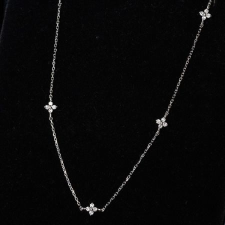 Collar de plata elegante que presenta intrincados racimos de flores hechos de circonitas cúbicas.