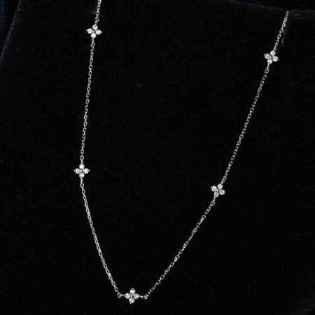 A luxurious silver necklace featuring a flower cluster charm with zircon stones.