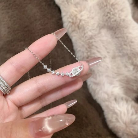 Close-up of the sterling silver celestial necklace held in hand to show scale.