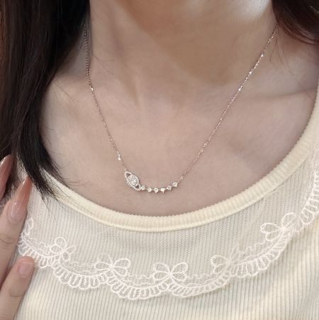 Collar de estrella y planeta celestial de plata esterlina 925 con diseño brillante - Una modelo usando el collar de estrella y planeta celestial de plata esterlina 925, mostrando su delicado diseño contra una blusa crema.